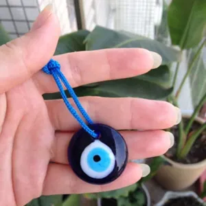 Detail of Turkish evil eye blue glass pendant amulet necklace hanging accessory charm.