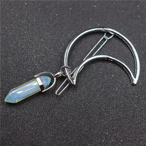 Detailed close-up shot of a elegant crescent moon metal hair clip with hexagonal crystal pendant.