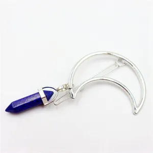 Detail shot of the blue crystal hexagonal pillar pendant and silver moon hair clip accessory.