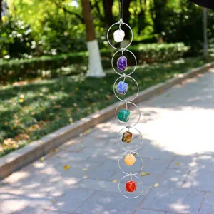 Wanddecoratie van ruwe edelstenen en kristallen met zeven chakra's en metalen ringen.
