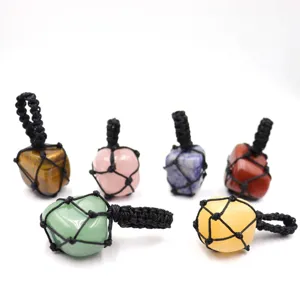 Close up detail of handmade woven crystal stone net pocket pendant necklace accessory.