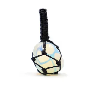 Closeup of handmade black woven net pocket holding a crystal gemstone pendant detail.