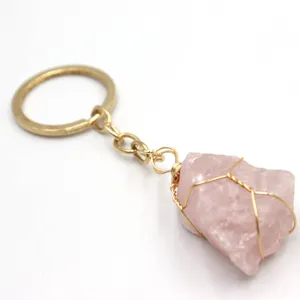 Portachiavi con pietra di cristallo di quarzo rosa grezza avvolta in filo dorato elegante