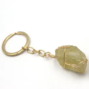 Dettaglio ravvicinato di un elegante portachiavi con pietra di cristallo e filo metallico.