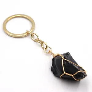Portachiavi con pietra grezza nera avvolta in filo metallico dorato dettaglio.