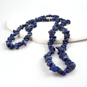 Dettaglio filo di perle di pietre preziose blu scuro, ideale per gioielli fai da te e accessori.