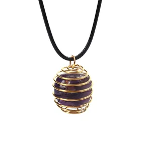 Detailaufnahme von lila Kristallstein im goldenen Drahtfederanhänger mit schwarzem Band.