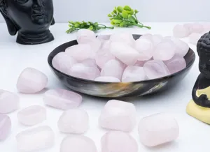 Close-up details view of natural polished rose quartz tumble stones for crystal decor.