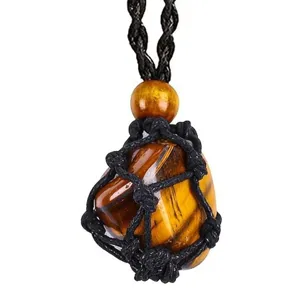 Close-up detail of natural tiger eye crystal stone in a black woven net rope necklace.