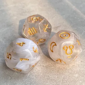 Constellation polyhedral dice set, marbled white resin with gold zodiac symbols and numbers.