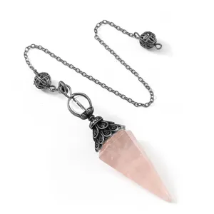 Primer plano del colgante de péndulo de cuarzo rosa natural con cadena de plata antigua.