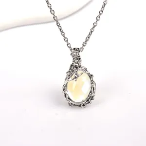 Detail shot of vintage bohemian style moonstone necklace with leaf vine pendant and silver chain.