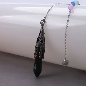 Detail van een vintage zwarte kristallen hexagon pendel ketting met chakra kralen voor meditatie.