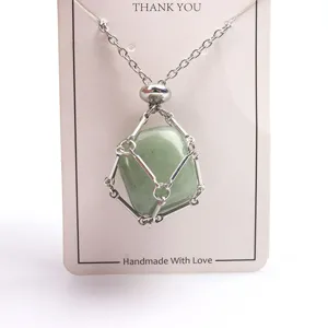 Dettaglio in primo piano della collana con ciondolo a gabbia in metallo e cristallo verde.
