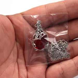 Retro style red gemstone pendant necklace with intricate silver-plated leaf and vine metal frame detail.