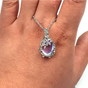 Detail view of a vintage bohemian moonstone pendant necklace with silver leaf branch design.