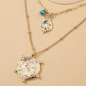Collana a più strati con ciondolo a moneta con ritratto, catene geometriche e cristallo.