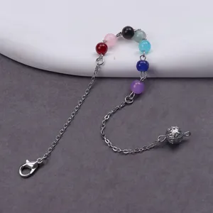 Gedetailleerde close-up van meerkleurige edelsteenkralen aan metalen ketting met decoratieve balhanger.