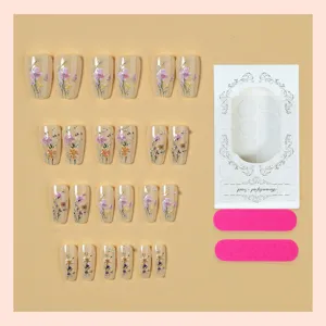 Set de uñas postizas con diseño floral elegante, perlas y forma larga para manicura.