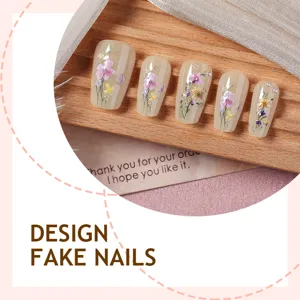 Vista detallada en primer plano de uñas postizas con delicado bordado floral y perlas.