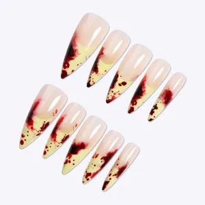 Superbes faux ongles longs stiletto avec un superbe motif d'éclaboussures de sang sur fond nude.