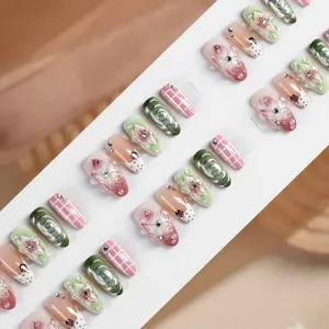 Almond press-on false nails set with 3D floral, green swirl, plaid and rhinestone designs.