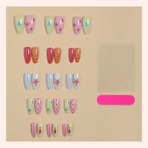 Detalle de uñas postizas almendradas con colores pastel, estrellas y diseños de peces.