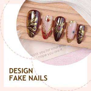 Detalle de uñas postizas de lujo con diseño floral dorado en relieve y degradado.