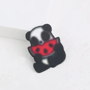 Gros plan sur la jolie broche en acrylique panda avec pastèque, texture lisse propre.