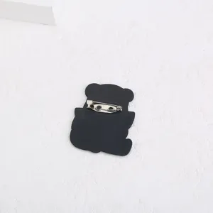 Vue arrière détaillée d'une broche ours dessin animé acrylique noir avec épingle métallique.
