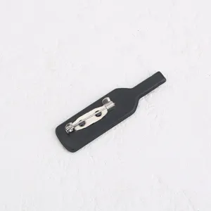Vue détaillée du dos d'une broche noire en forme de bouteille avec fermoir de sûreté.