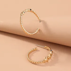 Detailed view of trendy gold hoop earrings featuring twisted rope and star patterns.
