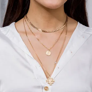 Vue détaillée d'un collier doré multicouche tendance avec pendentifs croix et pièce.