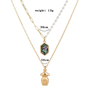 Collier double couche doré avec chaîne en perles, coquillage d'abalone et pendentif corps féminin.