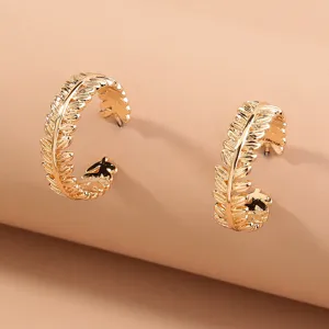 Golden leaf textured C-shaped hoop earrings, elegant metallic design detail close-up.