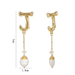 Vue détaillée de boucles d'oreilles lettre J en métal avec belle perle baroque.