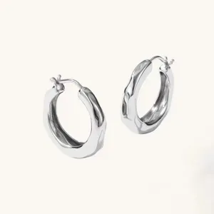 Silver irregular chunky hoop earrings close-up view minimalist fashion jewelry design