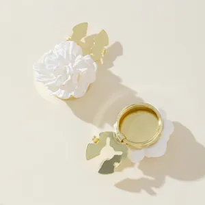 White flower button cover detail showing front floral design and gold metal clip back.