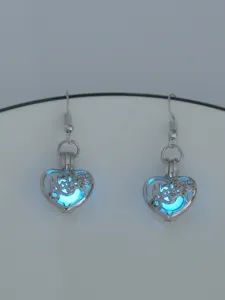 Detailansicht der leuchtenden Herz-Ohrringe, blaue Leuchtkugel im silbernen Metallkäfig.