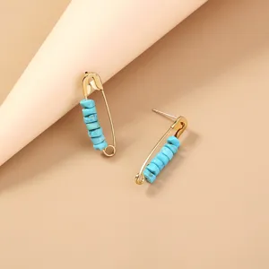 Turquoise bead safety pin stud earrings, chic gold metal bohemian style detailed jewelry piece.
