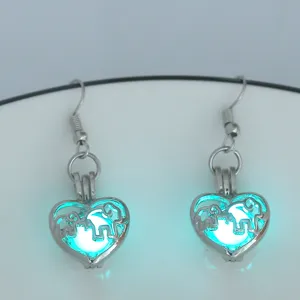 Detailaufnahme von leuchtenden Herz Elefant Ohrringen, lumineszierender Silberschmuck Nahaufnahme.