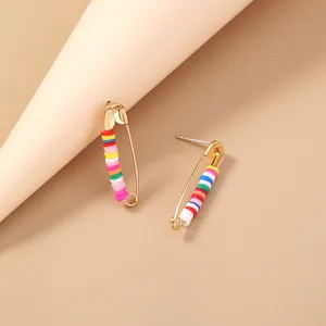 Gold-tone safety pin stud earrings featuring colorful polymer clay disc beads for a bohemian look.