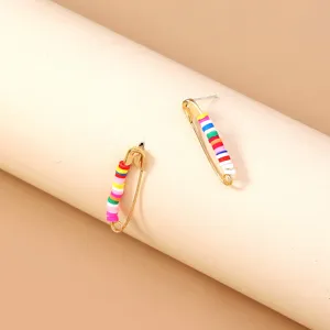 Detailed shot of bohemian style safety pin stud earrings with colorful polymer clay beads.