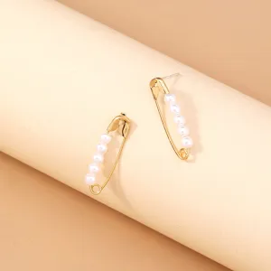 Gold safety pin earrings decorated with white pearls, chic and trendy fashion jewelry.