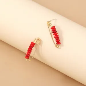 Bohemian style metal safety pin earrings with red soft pottery beads, unique detailed accessory.