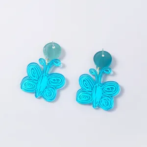 Blue acrylic butterfly earrings detail shot, showing cute hollow carved wing texture and shiny finish.