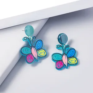 Detailed view of colorful acrylic butterfly earrings featuring unique doodle design and blue.