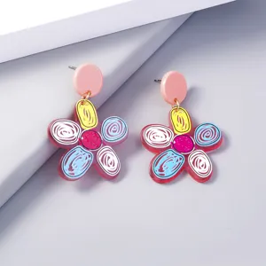 Close-up detail of colorful acrylic flower drop earrings with pink stud design.