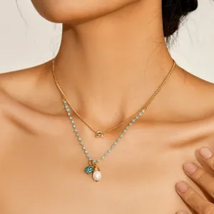 Dettaglio di una collana doppia di perle e turchese da donna in stile spiaggia estivo.