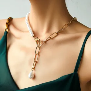 Primo piano dettagliato della elegante collana a clavicola con mezza perla e catena dorata.